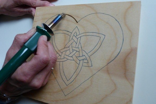 Go over the graphite tracings with a woodburning pen to burn the heart with Celtic knot into the wood