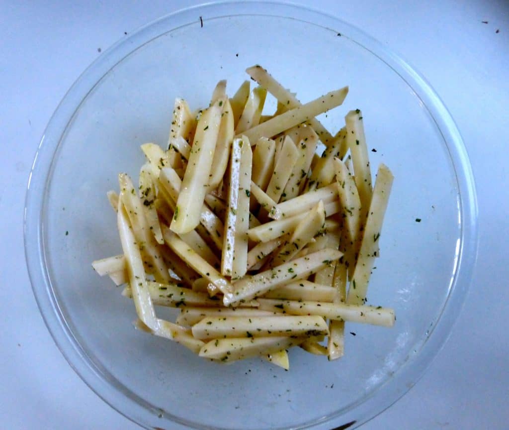 homemade fries - cut russet potatoes in bowl with olive oil and seasonings