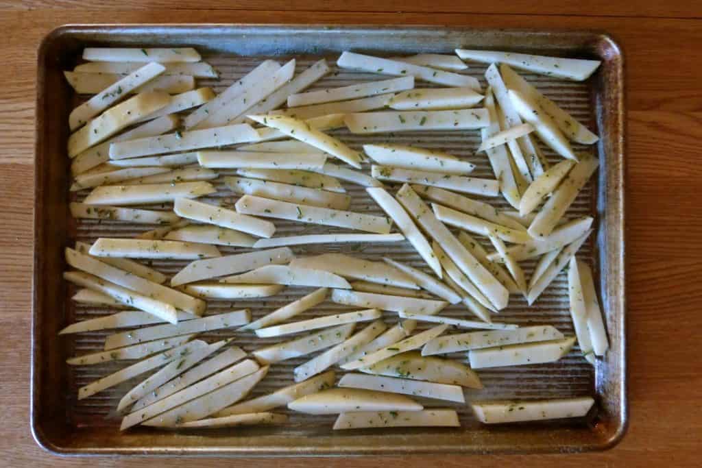 homemade french fries on cookie tray ready to put in oven to bake