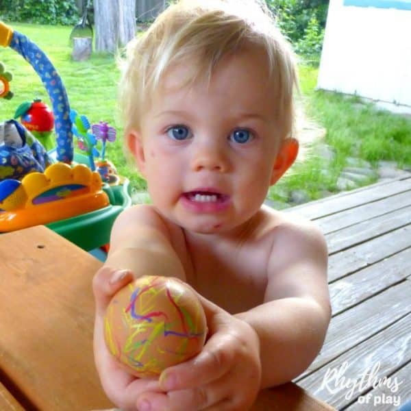 toddler decorating a natural brown egg