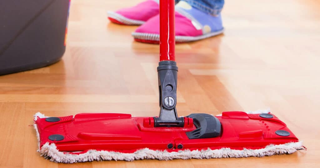 woman mopping wooden floor with diy natural homemade wood floor cleaner and polish