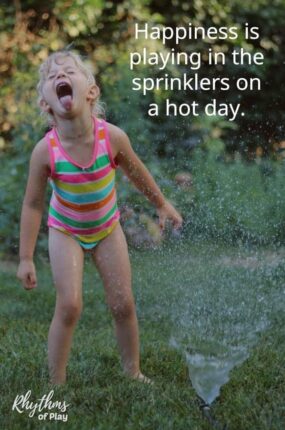 child playing in sprinkler having fun