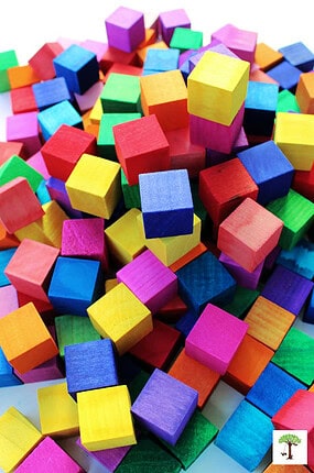 Stack of wooden DIY bocks in multiple bright translucent colors.