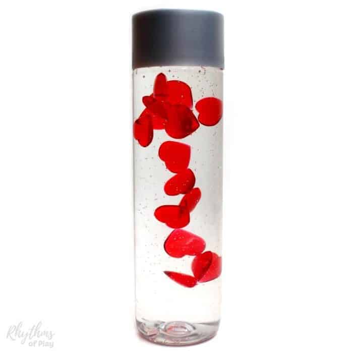 Slow falling hearts sensory bottle gift idea for Valentine's Day! The hearts are falling in love. (Made and photographed by Nell Regan K. founder of Rhythms of Play)