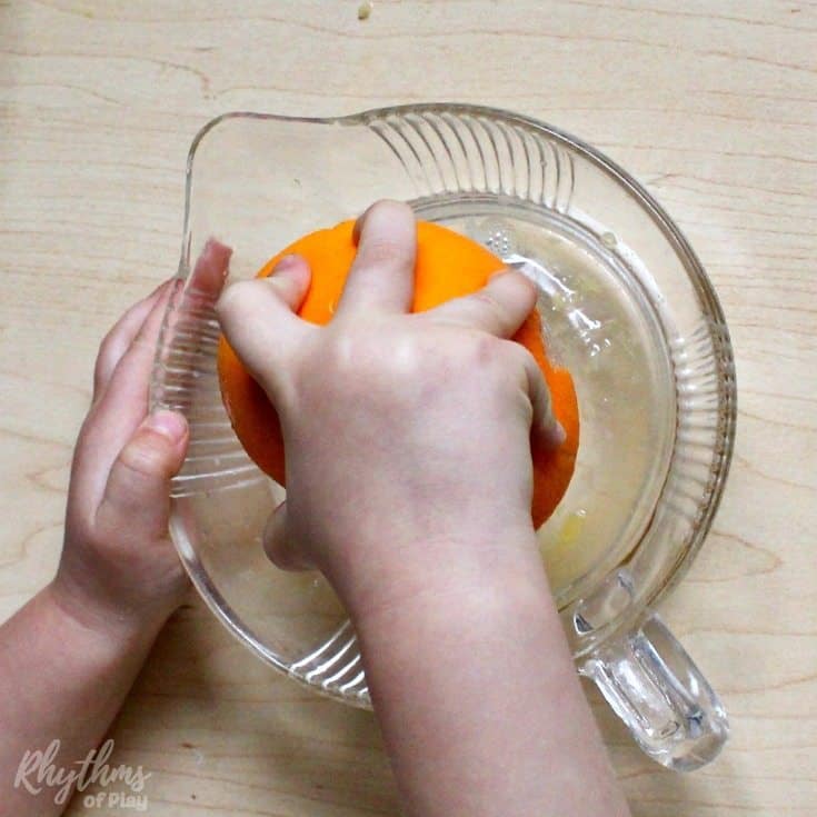 Squeezing an orange Montessori practical life activity is an easy first exercise in at home food preparation for kids. Kitchen learning activities help toddlers develop self-confidence and self-sufficiency in the kitchen, make preschoolers and kindergarteners feel like they are making a contribution at home, and help elementary aged kids develop cooking skills.