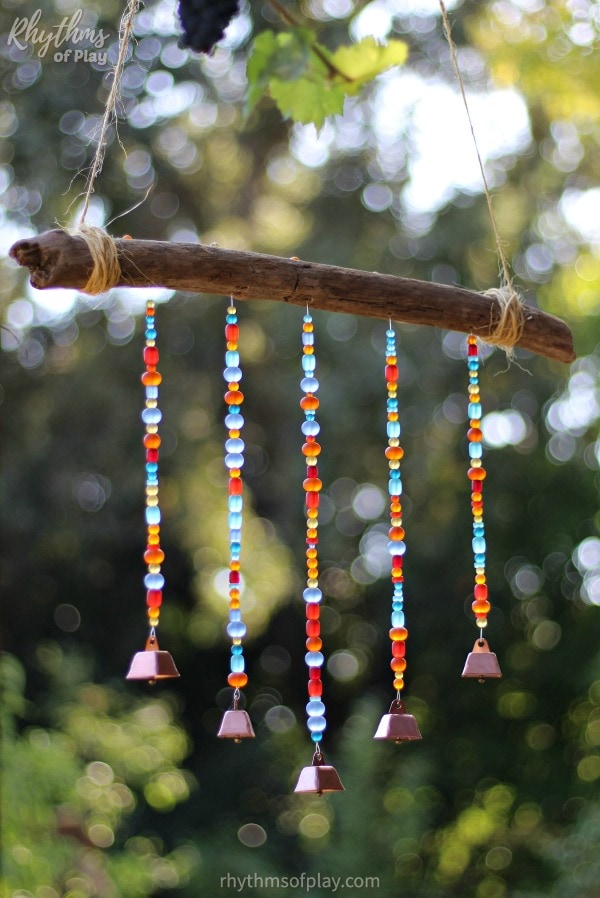 DIY wind chime craft made with sea glass beads, cowbells, and driftwood