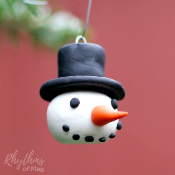Learning how to make homemade DIY polymer clay Snowman head ornaments is a fun holiday craft for both kids and adults. Handmade ornaments like these easy snowmen with top hats and winter caps are perfect for the Christmas tree. Cute smiling faces like these make beautiful decorations and a great kid-made gift idea!