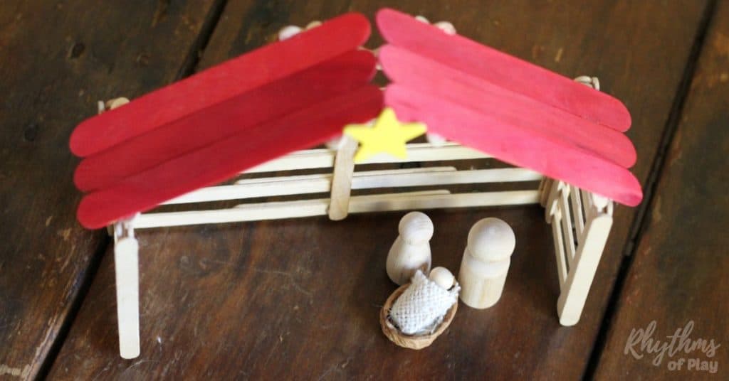 DIY Christmas Nativity Scene Display with popsicle stick stable and wooden holy family.