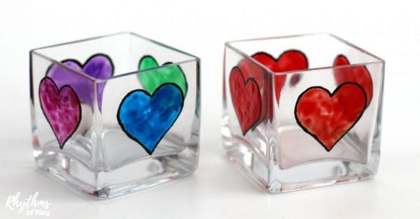 DIY faux stained glass heart candle holders sitting on a table (heart crafts and photos by Nell Regan K and Charlize Kartychok co-founders of Rhythms of Play)