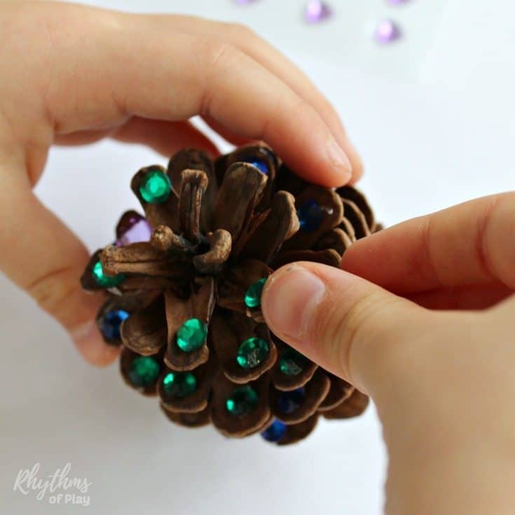 Add a little rustic bling to your Christmas tree with DIY rhinestone pinecone ornaments! An easy kid-made book-inspired Christmas nature craft kids and adults both enjoy crafting for the holidays.