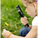 child looking through a magnifying glass
