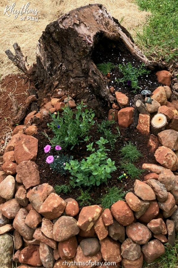 fairy garden tree stump - DIY fairy garden made in a tree stump with a stone stacked container