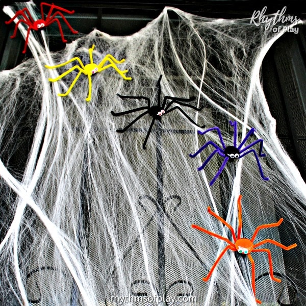 multi-colored Halloween spider magnet decorations on a front porch security door