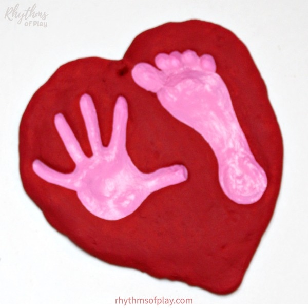 red salt dough heart with pink handprint and footprint art