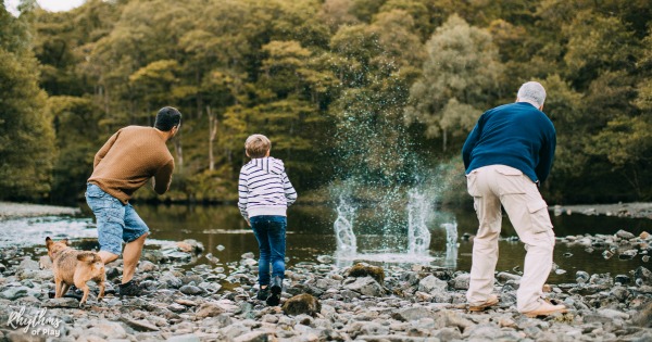 family throwing rocks and skipping stones