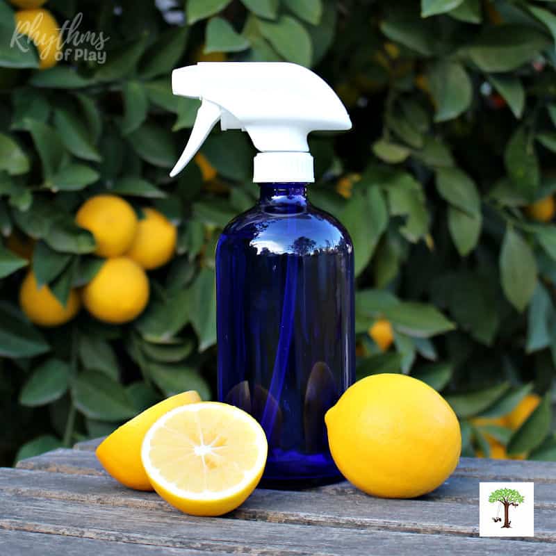 all-purpose cleaner DIY recipe in a blue spray bottle on a table with lemons