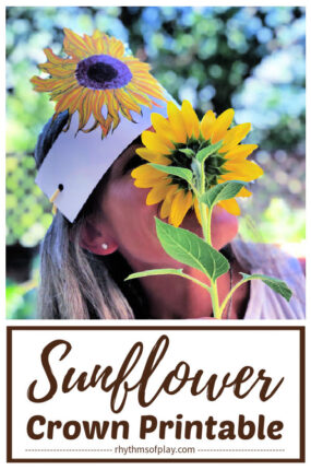 woman wearing a paper flower crown that looks like a sunflower tiara and looking through the petals of a sunflower (photo of Nell Regan Kartychok)