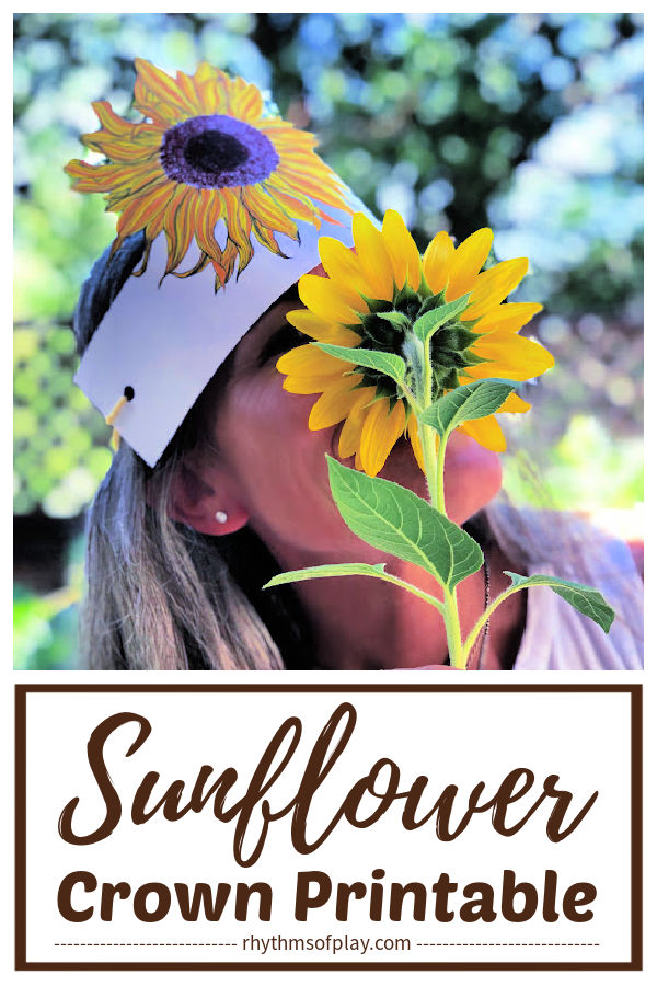 woman wearing a paper flower crown that looks like a sunflower tiara and looking through the petals of a sunflower (photo of Nell Regan Kartychok)