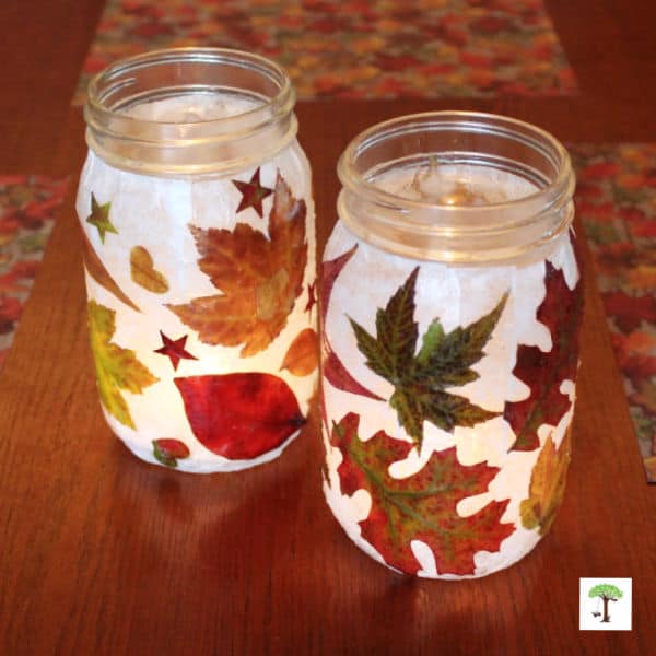 DIY lanterns made with natural fresh fallen autumn leaves with fairy lights inside the fall luminaries.