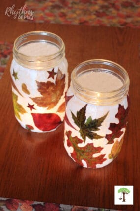 DIY leaf lantern crafts lit with a candle on a fall-themed table.