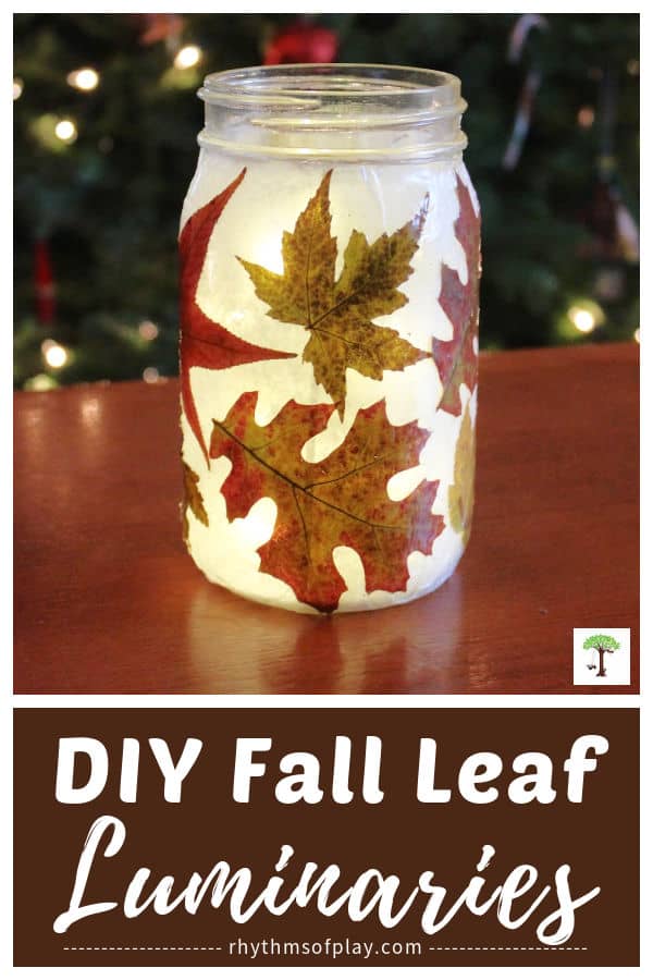 Gorgeous DIY fall leaf lantern sitting on a table with natural autumn leaves glowing with light. 