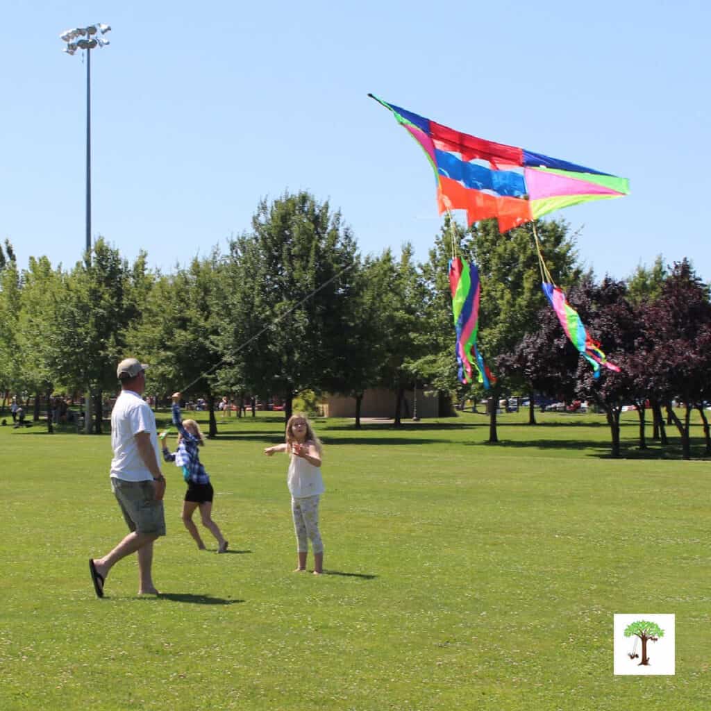 kids demonstrating how to do a running kite launch to fly a kite (photo of Caydence Davis, Nick and Charlize Kartychok by Nell Regan Kartychok founders of Rhythms of Play)