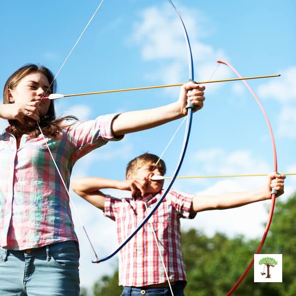 Kids practicing archery; aiming to shoot arrows on Lughnasadh to celebrate the first fall harvest