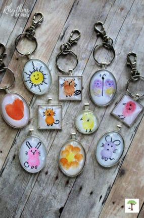 Examples of fingerprint art keychain pendants and backpack charm crafts you can make with kids.