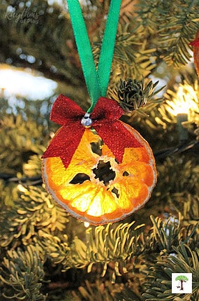 DIY orange slice ornaments crafts decorating a Christmas tree.